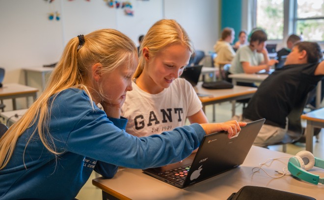 To jenter spiller Numetry sammen på en PC i et klasserom